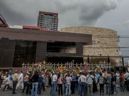 Familiares de las víctimas del incendio colocan flores a las afueras de lo que antes era el casino Royale. ARCHIVO /