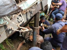 Personal de Protección Civil Tabasco maniobra para rescatar el cuerpo de unas de las víctimas. EFE /