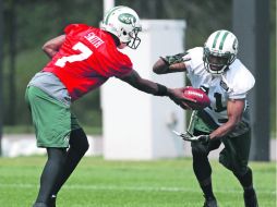 El pasador novato Geno Smith le entrega el ovoide al corredor Mossis Madu, durante el entrenamiento de los Jets. AP /