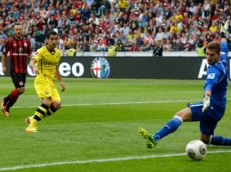 Henrikh Mkhitaryan define ante la salida del portero para anotar uno de sus dos goles del partido. AP /