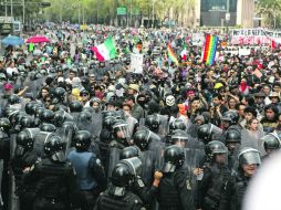 Manifestantes encapuchados y policías antimotines durante los enfrentamientos ayer, cuando se dirigían a la Cámara de Diputados. EFE /