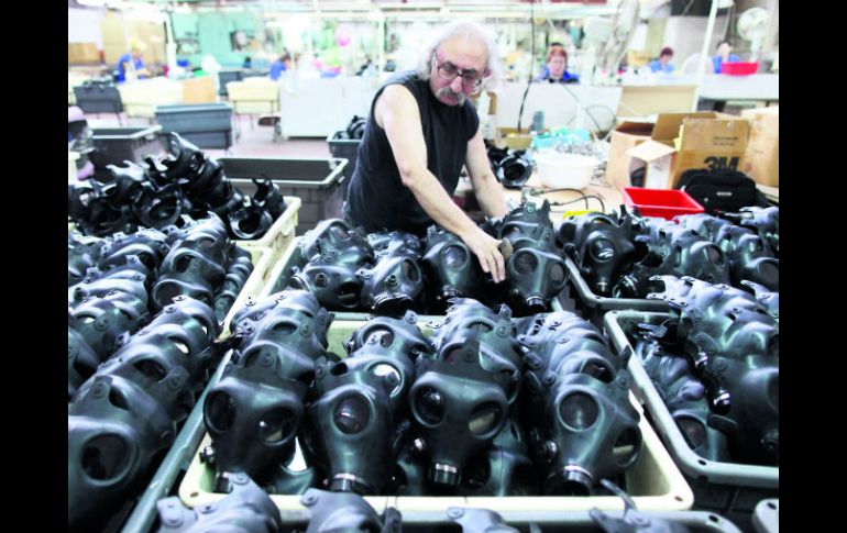 Un empleado de la fábrica de máscaras de antigás más grande de Israel, en Kiryat Gat, acomoda los artefactos. EFE /