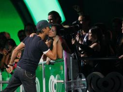 Durante un concierto, Enrique Iglesias deposita un beso en una admiradora. ARCHIVO /