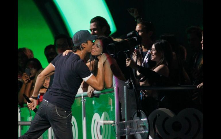 Durante un concierto, Enrique Iglesias deposita un beso en una admiradora. ARCHIVO /