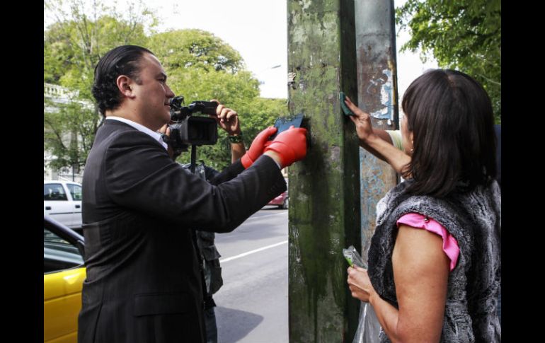 Manuel Herrera limpia un poste como muestra de las actividades que se llevaran a cabo por el aniversario de la Vía RecreActiva.  /