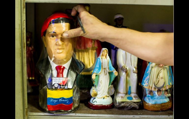 Aspecto de la imagen del ex presidente de Venezuela junto a la de la virgen, en una tienda de venta de artículos religiosos. EFE /