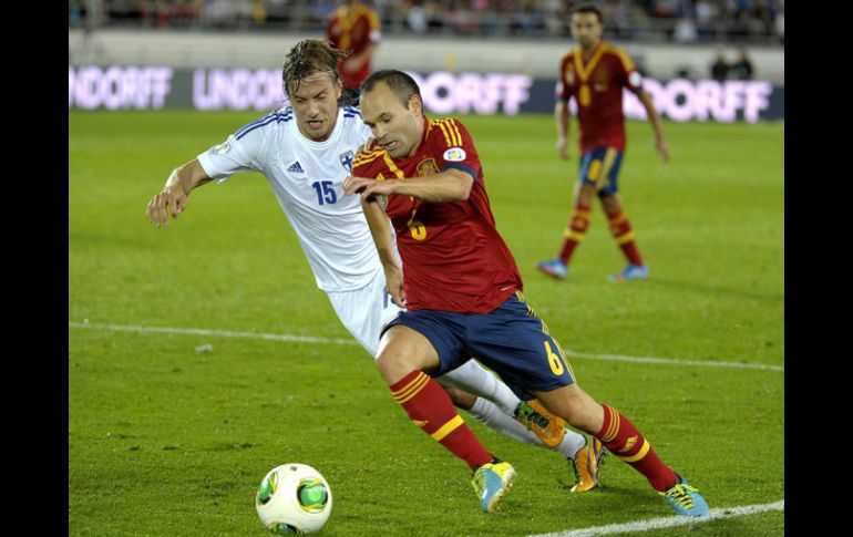 Andrés Iniesta busca debosrdar a un defensa de Finlandia en el partido celebrado hoy en Helsinki. EFE /