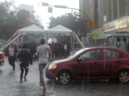 Jóvenes buscando resguardo en toldos o negocios de la zona fueron la escena constante durante la lluvia. EL INFORMADOR /