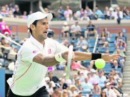 Novak Djokovic regresa una pelota durante la semifinal, la cual ganó por parciales de 2-6, 7-6 (4), 3-6, 6-3, 6-4. AFP /