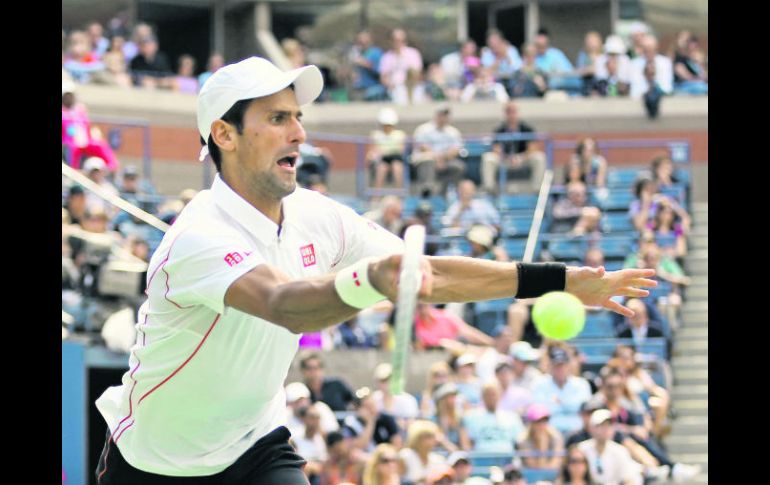 Novak Djokovic regresa una pelota durante la semifinal, la cual ganó por parciales de 2-6, 7-6 (4), 3-6, 6-3, 6-4. AFP /