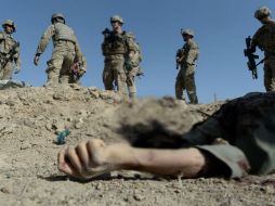 Soldados norteamericanos miran el cuerpo de un hombre en Maidan, una provincia al sur de Kabul. AFP /