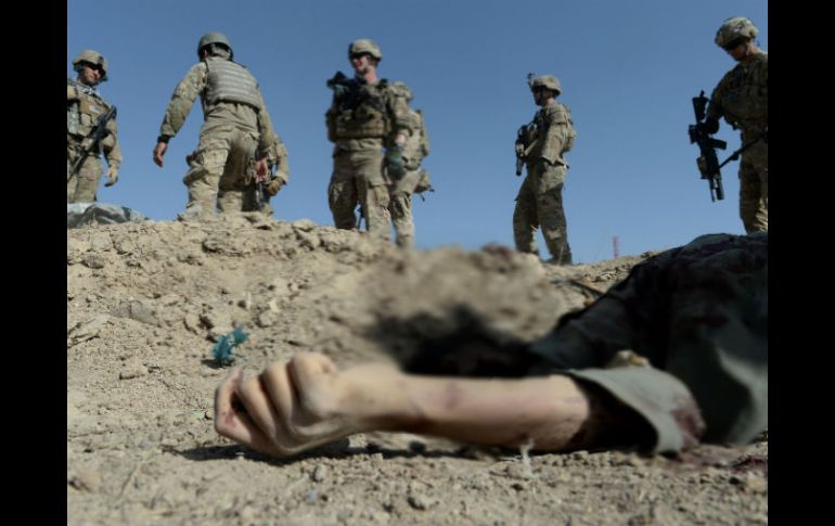 Soldados norteamericanos miran el cuerpo de un hombre en Maidan, una provincia al sur de Kabul. AFP /