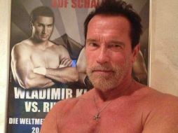 Arnold Schwarzenegger aparece sin camisa y con el póster del boxeador en el fondo. Tomada de @Schwarzenegger en Twitter. ESPECIAL /