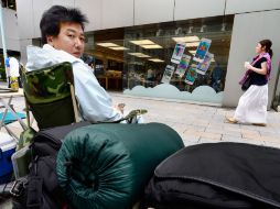 Un hombre espera fuera de una tienda de Apple en Tokio para poder adquirir el nuevo iPhone 5s. AFP /