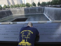 Un hombre acude al memorial de las víctimas a rezar y mostrar sus respetos. AP /