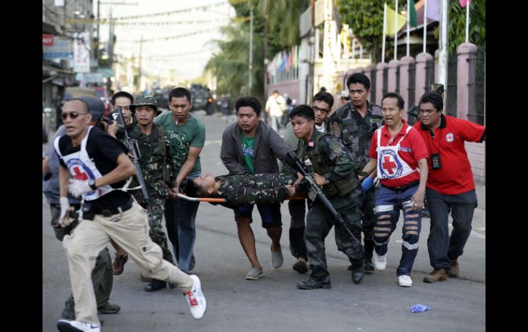 Soldados filipinos y miembros de la Cruz Roja trasladan a un soldado herido en un ataque con proyectiles de mortero. EFE /