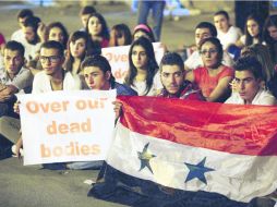 Habitantes de Damasco sostienen pancartas y banderas durante una sentada de protesta contra una eventual acción militar contra Siria. AFP /