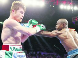 Floyd Mayweather Jr. conecta con la izquierda hacia el rostro del jalisciense, quien perdió la pelea por decisión dividida. AFP /