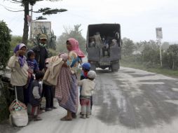 Habitantes afectados esperan para evacuar en una calle cubierta por ceniza volcánica. AP /