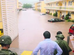 Un soldado y un civil observan la inundación en un hotel de Chilpancingo, ocasionada por las lluvias de la tormenta tropical ''Manuel'' AFP /