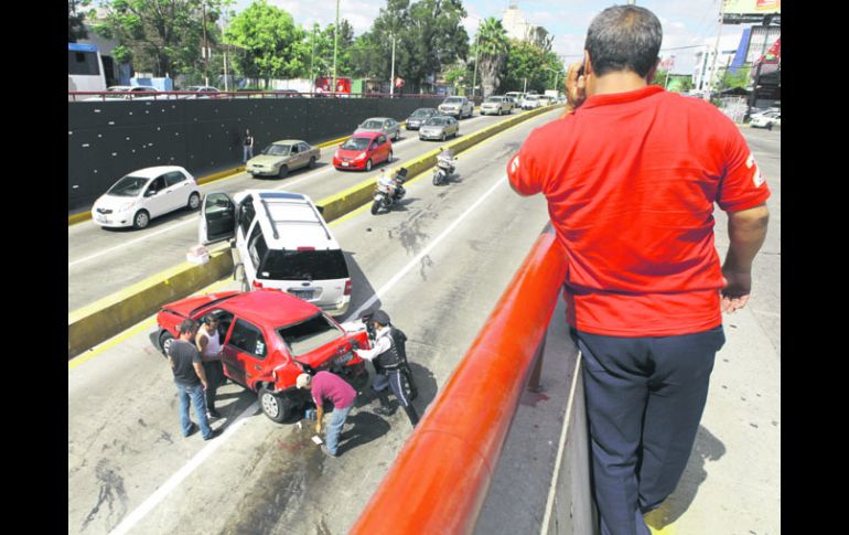 BLOQUEO. Policías viales auxilian a los automovilistas involucrados en un percance sobre Avenida López Mateos. EL INFORMADOR /