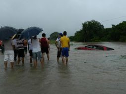 Un grupo de habitantes observa a un vehículo afectado por el desbordamiento del río Guamol, en Oaxaca. EFE /