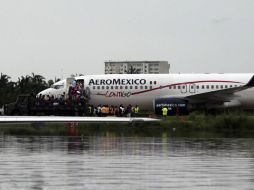 Militares ayudan a pobladores a abordar un avión para ser evacuados del puerto de Acapulco. AFP /