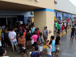 Docenas de personas intentan comprar alimentos en una tienda en el puerto de Acapulco. EFE /