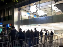 Personas hacen fila afuera de una tienda de Apple antes de ser abierta. EFE /