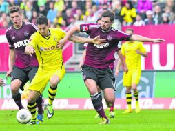 Robert Lewandowski, del Borussia Dortmund, conduce el balón entre Niklas Stark y Per Nilsson del Nuremberg. AFP /