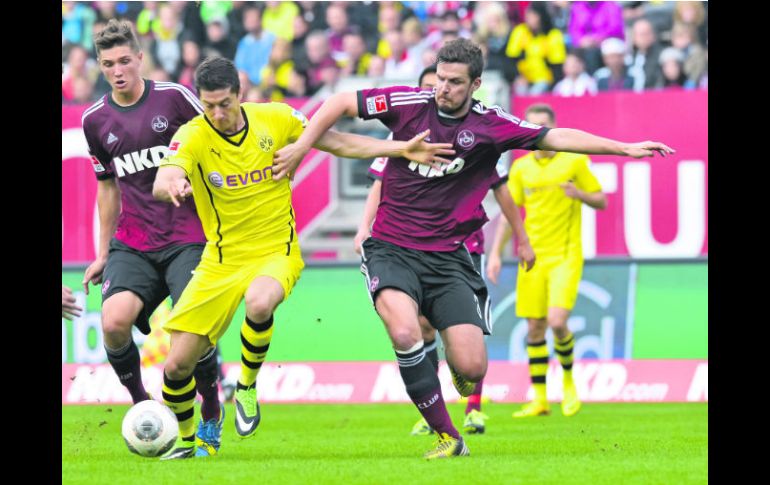 Robert Lewandowski, del Borussia Dortmund, conduce el balón entre Niklas Stark y Per Nilsson del Nuremberg. AFP /