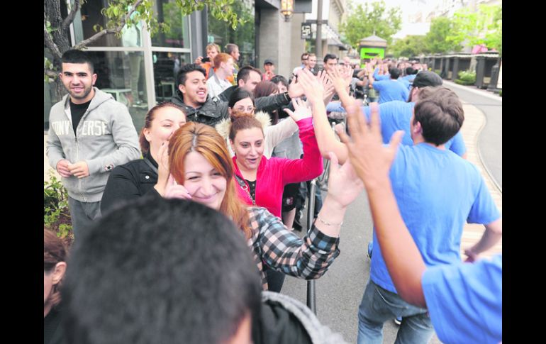 Reconocimiento. Los fanáticos de la tecnología recibieron la felicitación de los empleados de las tiendas Apple como premio a su espera AFP /