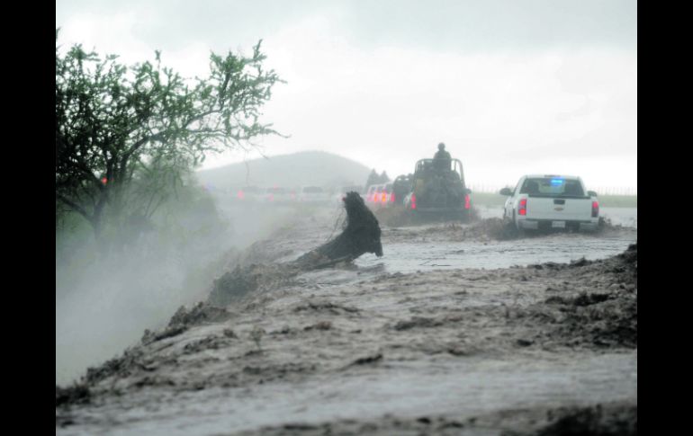 Elementos del Ejército escoltan a damnificados tras la crecida del río en El Zapotillo, en el municipio de Ahome. AP /