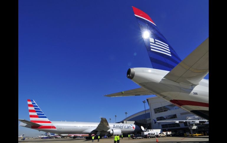 Dos aviones de American Airlines (i) y US Airways (d), tras el anuncio de fusión. EFE /