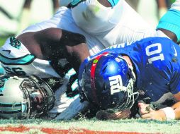 El defensivo de Carolina, Charles Johnson, captura detrás de la línea de golpeo al mariscal de campo de Nueva York, Eli Manning. AP /