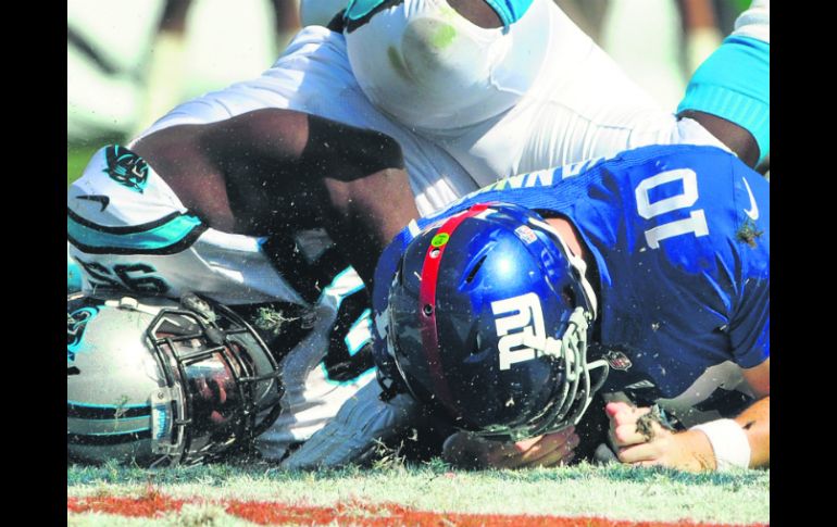 El defensivo de Carolina, Charles Johnson, captura detrás de la línea de golpeo al mariscal de campo de Nueva York, Eli Manning. AP /