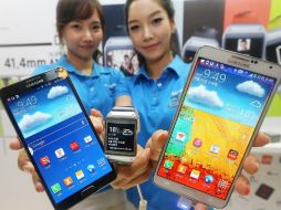 Dos azafatas muestran la nueva tableta Samsung Galaxy Gear smartwatch y el móvil Galaxy Note 3 (centro). AFP /