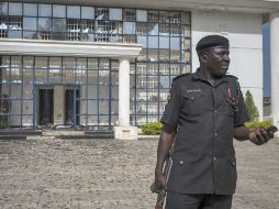 Un polícia nigeriano frente a un edificio dañado por las explosiones y tiroteos. EFE /