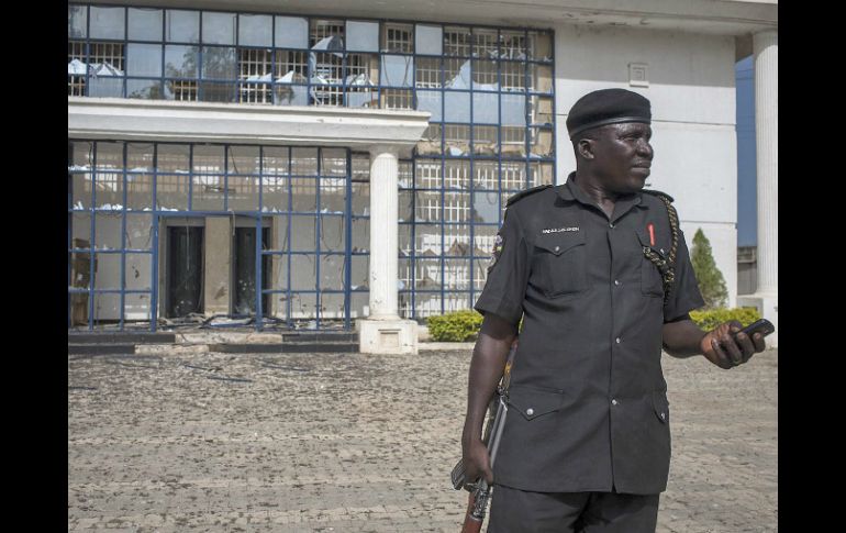 Un polícia nigeriano frente a un edificio dañado por las explosiones y tiroteos. EFE /