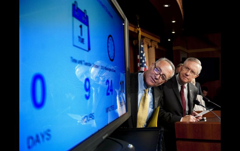 El líder de la mayoría en el Senado, Harry Reid (d) mira la pantalla del tiempo que queda hasta el cierre del gobierno. AFP /