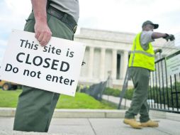 Dos empleados del servicio de parques de Estados Unidos colocan vallas y carteles que impiden el paso al Memorial Lincoln. EFE /