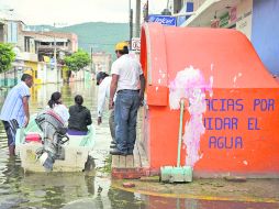 PARADOJAS. Habitantes de Tixtla usan lancha para transportarse por las calles de su comunidad, tras las inundaciones. NTX /