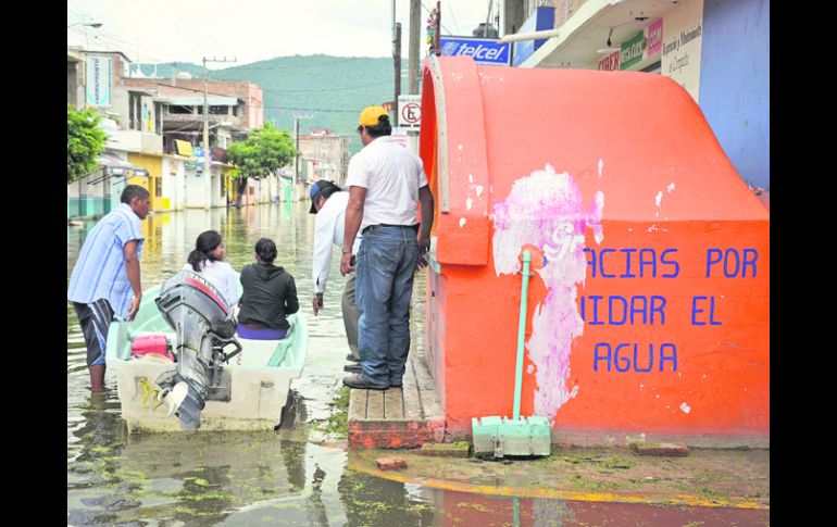 PARADOJAS. Habitantes de Tixtla usan lancha para transportarse por las calles de su comunidad, tras las inundaciones. NTX /