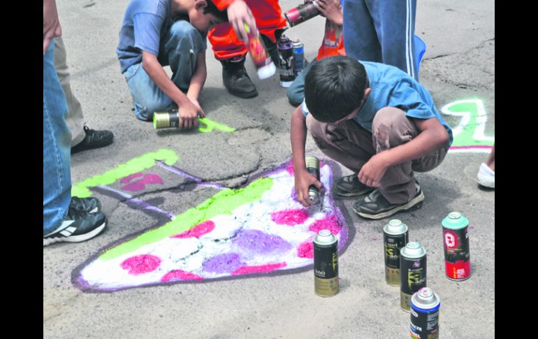 Multicolor. Vecinos de todas las edades colaboran en la pinta de baches, sumándose a la causa de este movimiento. ESPECIAL /