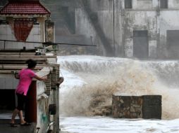 Aquí, una mujer ve como el agua corre por las calles de su ciudad. AFP /