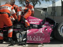 Técnicos de IndyCar tratan de sacar de su auto a Darío Franchitti después de sufrir su accidente. AP /