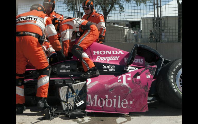 Técnicos de IndyCar tratan de sacar de su auto a Darío Franchitti después de sufrir su accidente. AP /