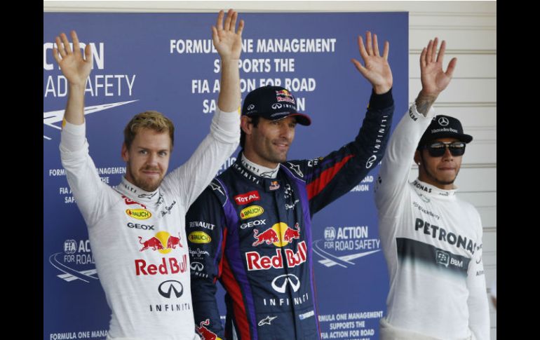 Mark Webber, de Red Bull celebra la obtención de la ''pole'', lo secundan su coequipero Sebastian Vettel y Lewis Hamilton, de Mercedes. AP /