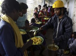 Evacuados reciben comida en un albergue. AP /