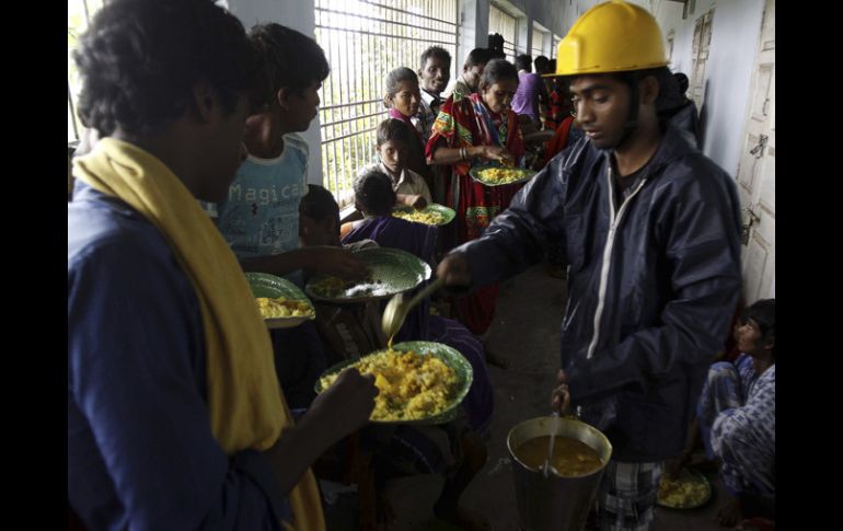 Evacuados reciben comida en un albergue. AP /